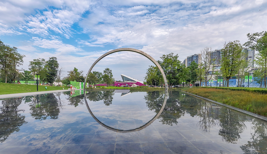 夏日的蓝天白云下一个半圆形景观倒影在水面上