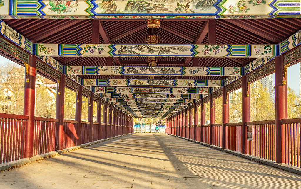 一游客正在通过古典式长廊步行桥