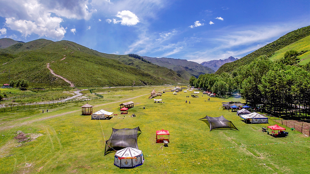 春日的蓝天白云下山谷中的露营地