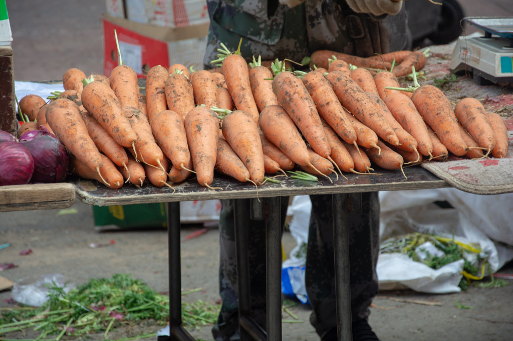 早市上售卖胡萝卜的摊位