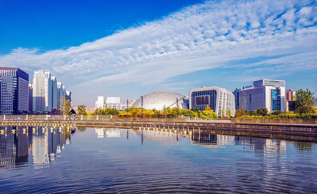 秋日的清晨蓝天白云下的青海科技馆倒影在水面上