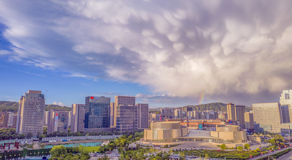 夏日雨过天晴白云在蓝天上翻滚彩虹挂在天边