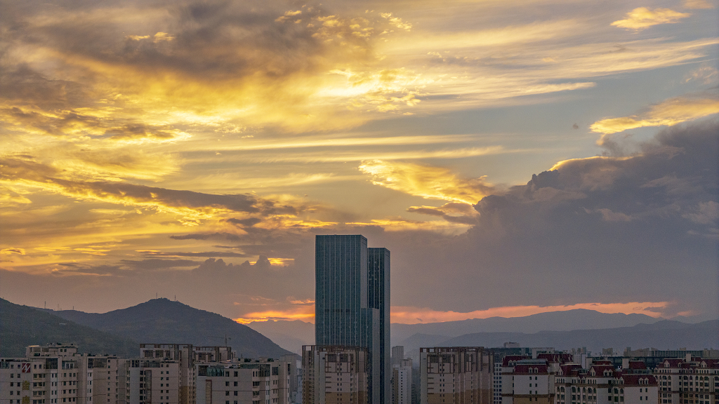 晚霞将天空染成了金黄色高楼山峰在云端