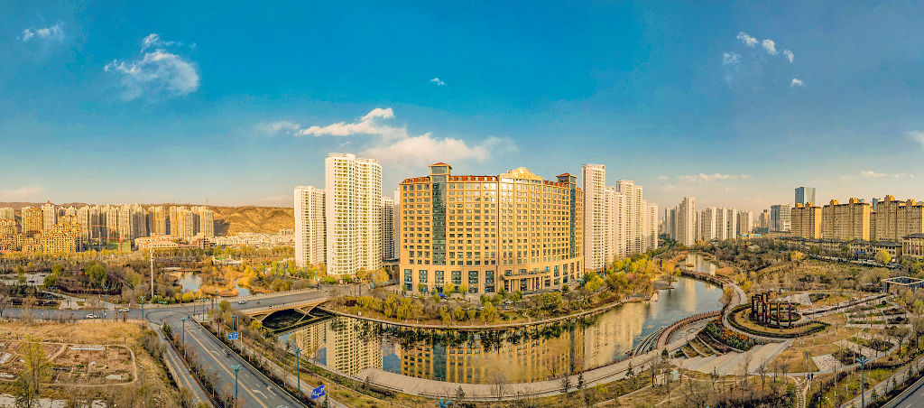 初冬季节蓝天白云航拍傍晚霞光下的城市建筑群