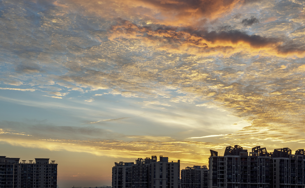 夏日的日出时分天空火烧云下城市高楼的剪影