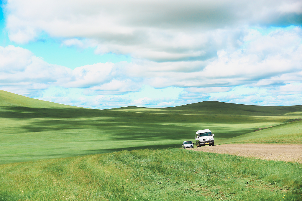 蓝天白云汽车草原行驶