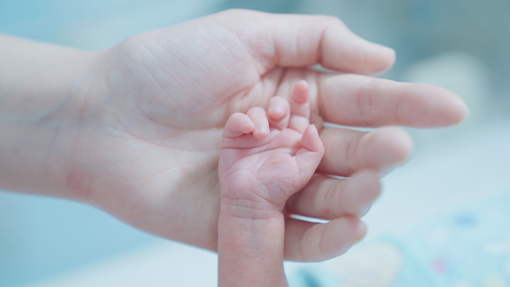 婴儿小手在母亲大手上母爱新生儿母亲节