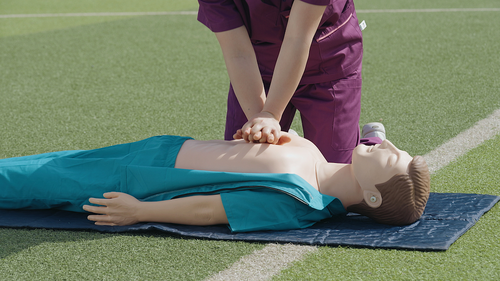 草地上护士给病人心肺复苏急救
