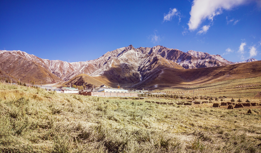 初冬时节蓝天白云下的山峰和农作物