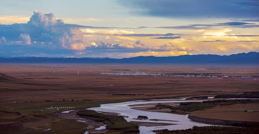 日落时分草原上弯弯曲曲的河流和天空彩色的云