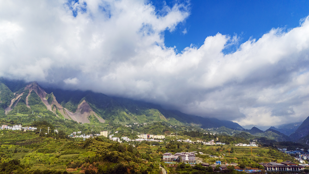 日出时分蓝天白云航拍大山脚下的民宿