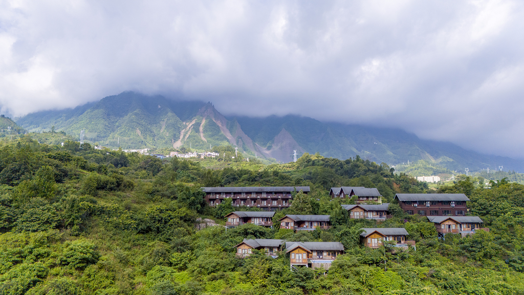 日出时分航拍大山下的民族小屋