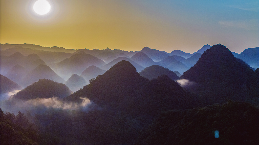 夏日的清晨航拍群山间的薄雾和初升的太阳
