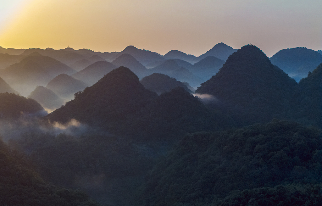 夏日的清晨航拍群山间的薄雾和群山的剪影