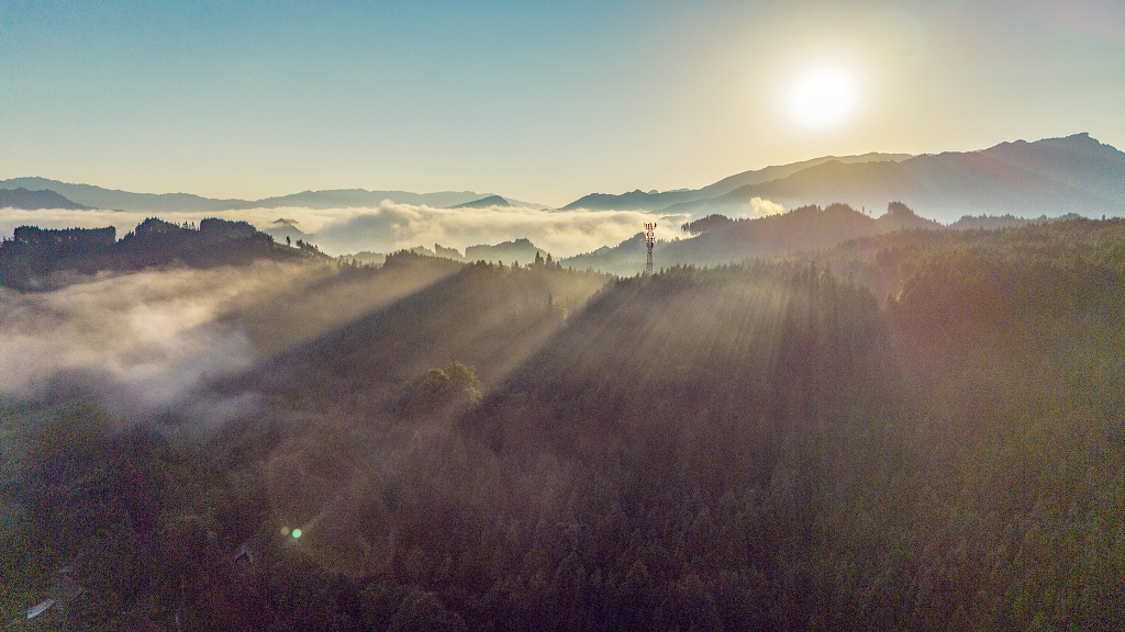 夏日的清晨航拍大山深处的丁达尔光束和云雾及太阳
