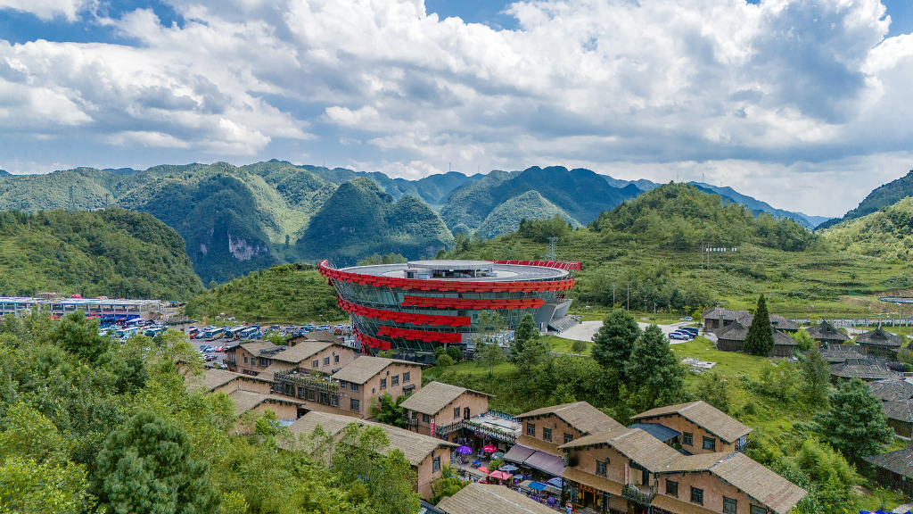 晴朗的夏日航拍蓝天白云下的贵州彝族村的房屋及现代建筑