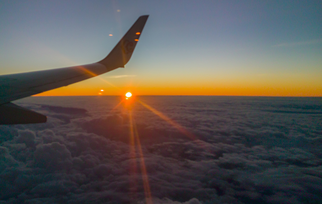 从飞机上拍摄日落时分的太阳彩云和机翼