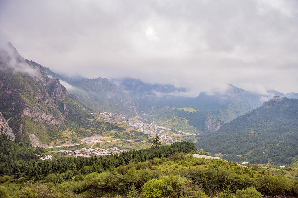初秋的早晨云雾缭绕下的甘肃扎尕那的高山下的小村庄