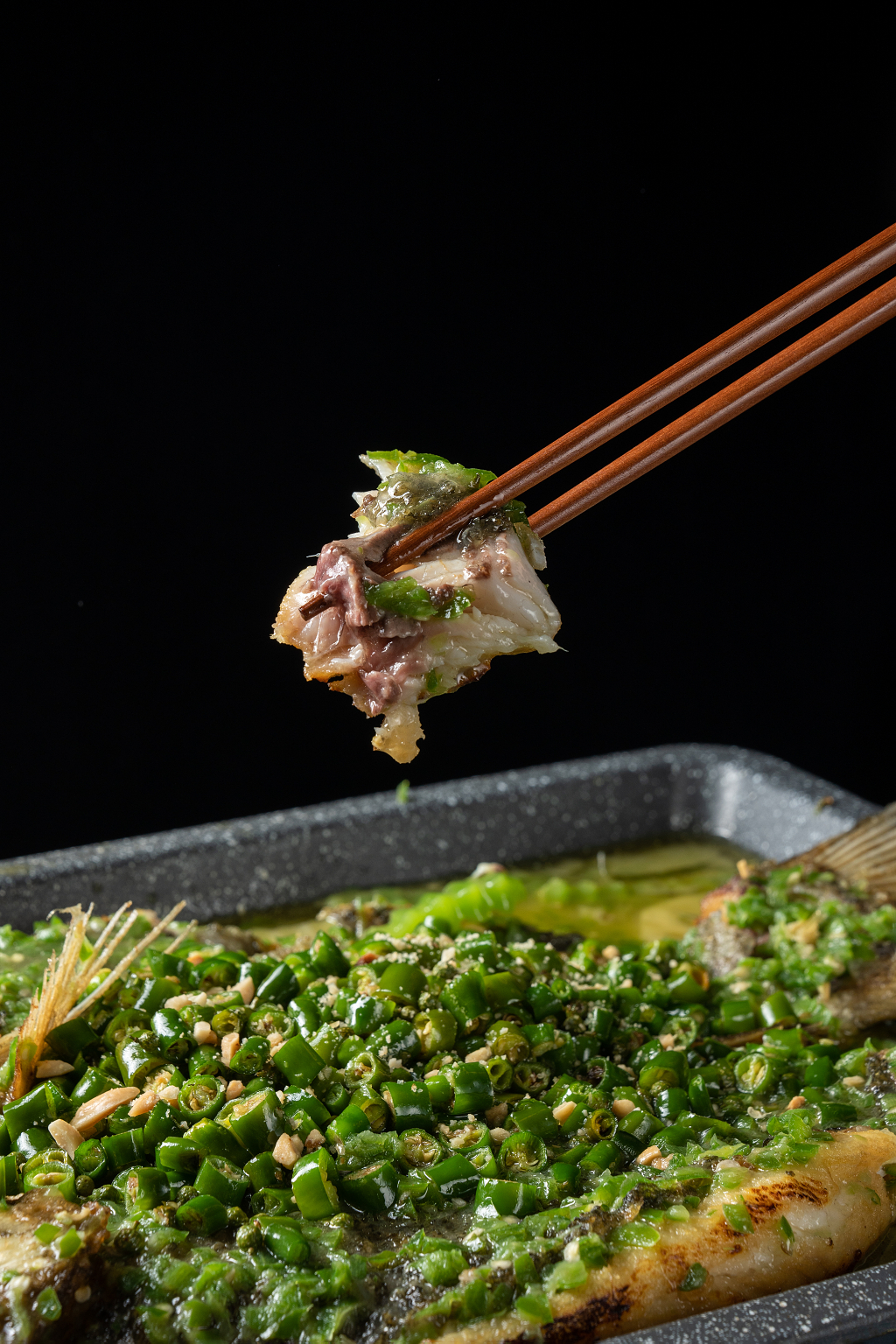 筷子夹起青椒烤鱼