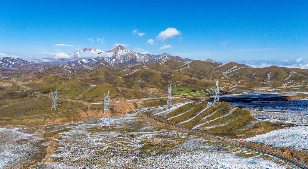 初雪的清晨拉脊山顶的草山和输电线路