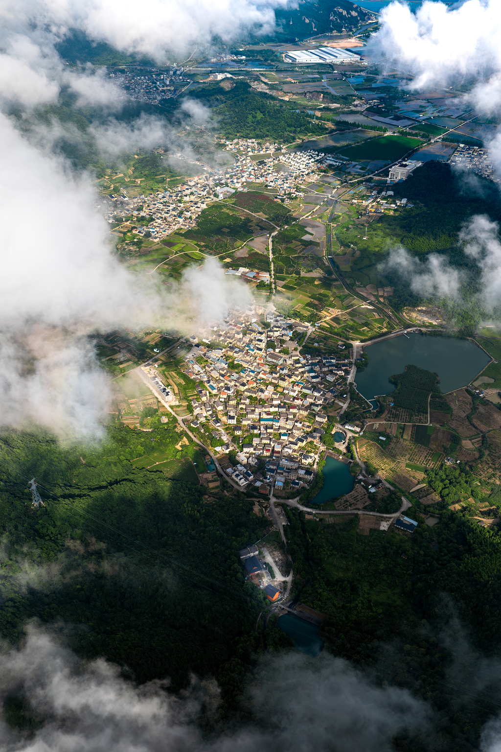 航拍云海下的藏在山谷里的新农村建设