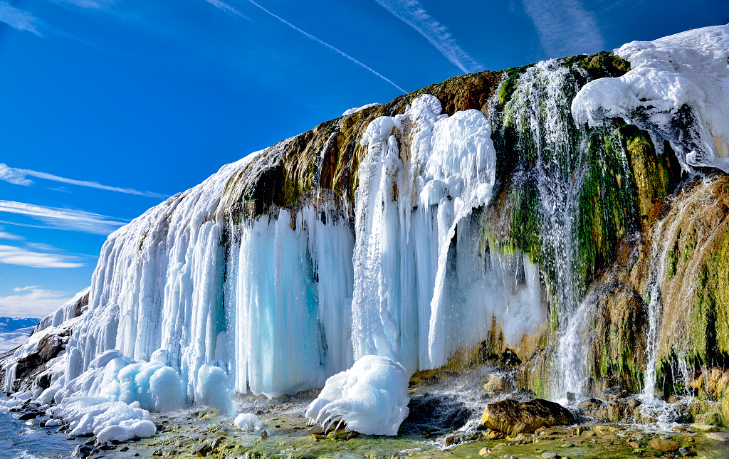 晴朗冬日冬天的上午阳光照亮了青海岗什卡雪山下的七彩瀑布大自然风景风光