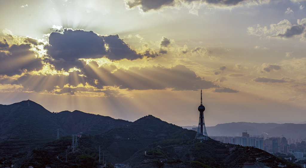大自然风光风景日落时分西宁上空太阳在云彩后面发出的丁达尔光