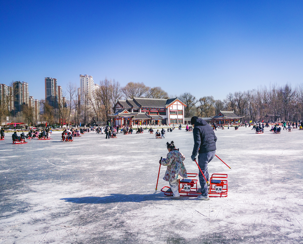 冬天冬日的午后在公园的结冰湖面上滑冰的市民