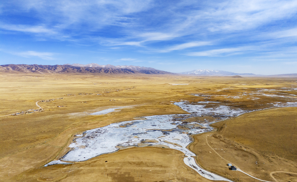 冬日航拍蓝天白云下的青海湖湖畔的草原和冰封的湖面大自然风景风光