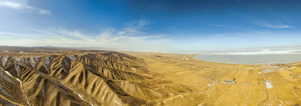 冬日的午后航拍青海湖畔金黄色的雪山大自然风景风光