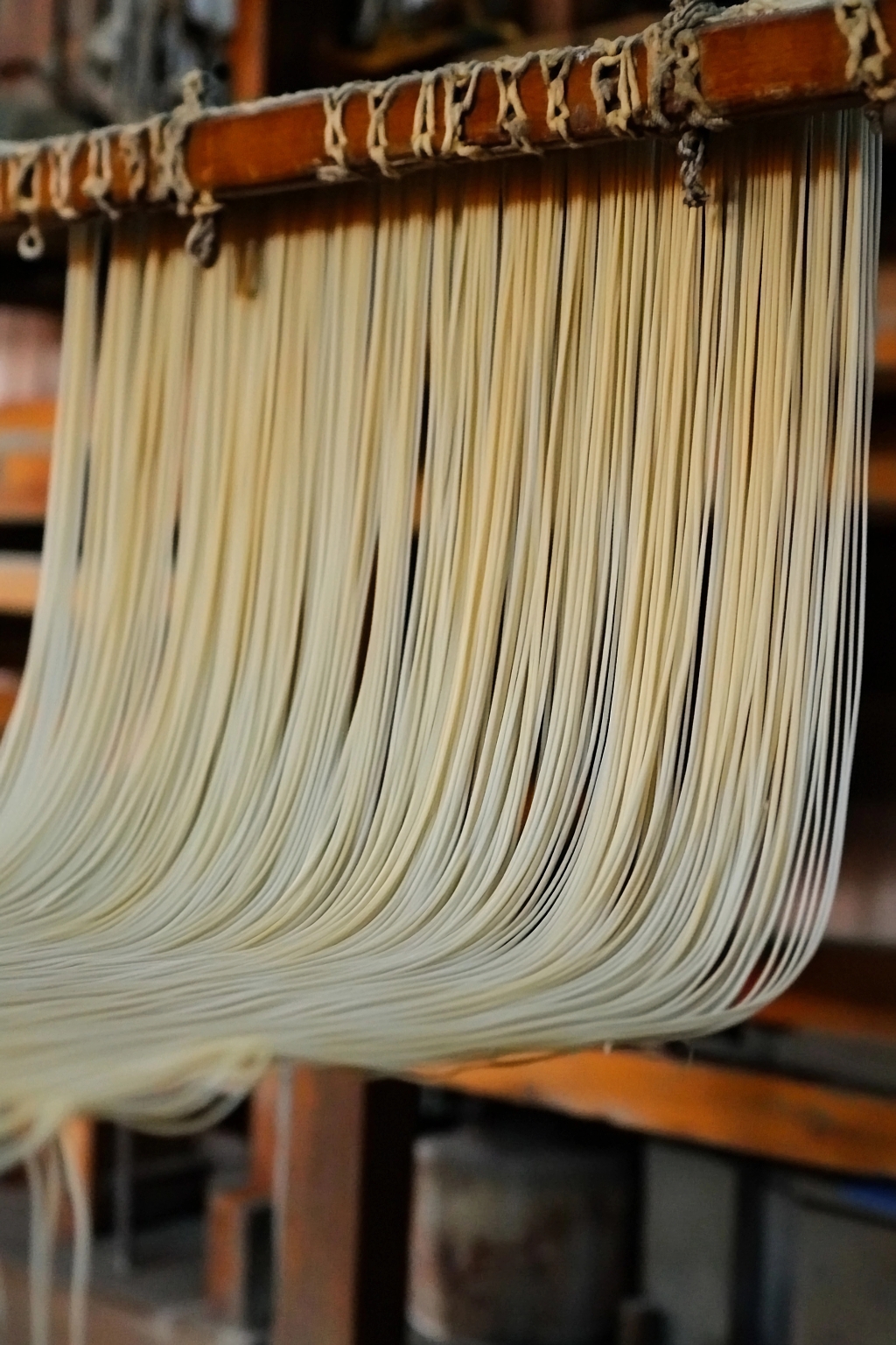 传统挂杆上晾晒的手工面条充满质朴质感AI