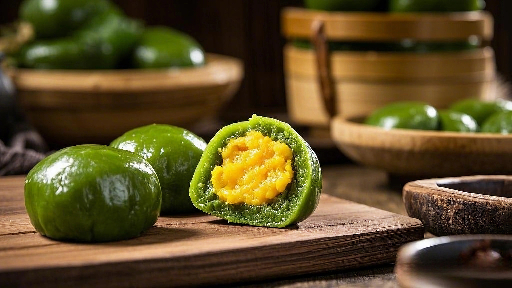 木砧板上切开露出蛋黄馅的清明节青团AI