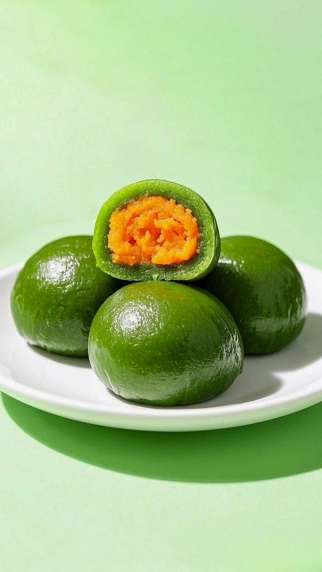 白色盘子上摆放着切开露出蛋黄馅的清明节青团AI