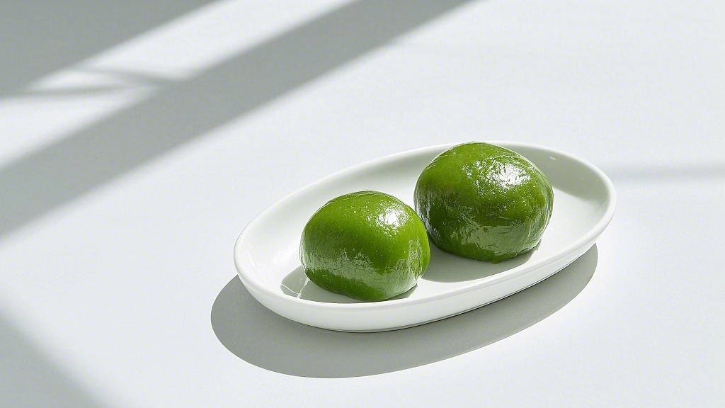 白色盘子上摆放着两颗诱人的清明节青团AI