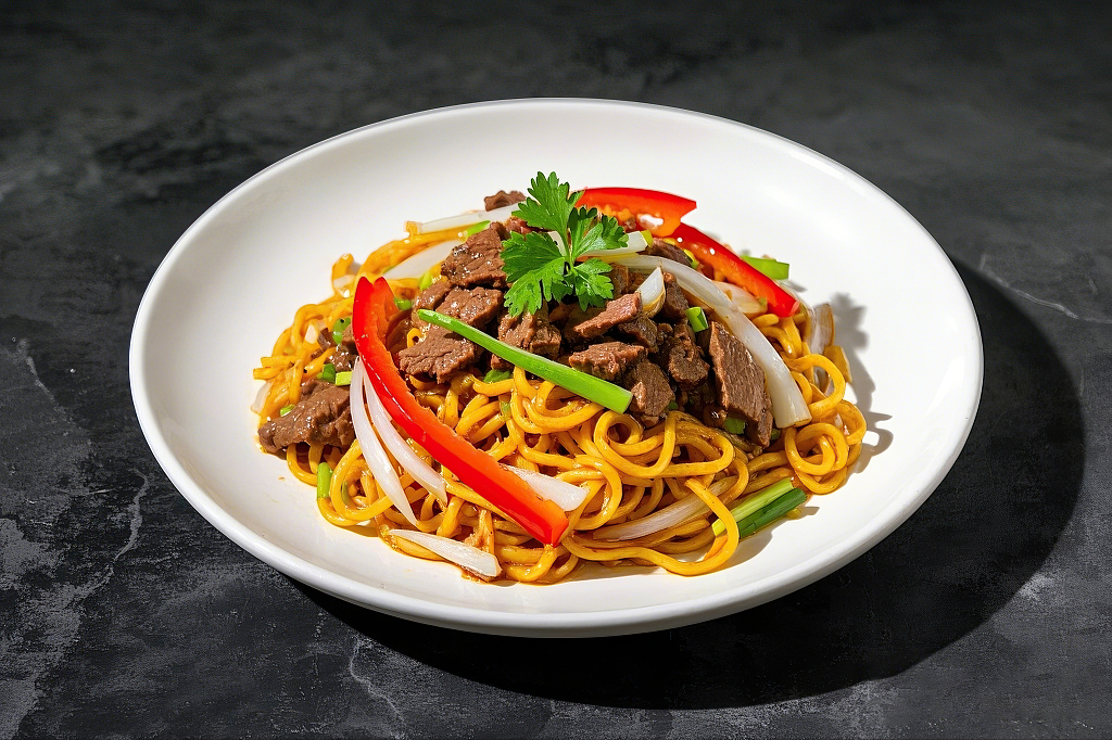 白色盘子里摆放着牛肉红椒洋葱葱段组合的特色炒面意大利面	AI