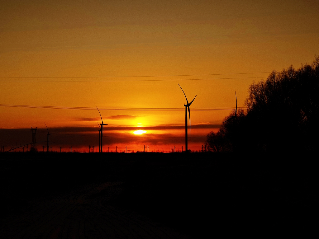 冬日夕阳郊外的风景风力发电风车剪影