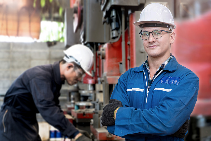 工厂工程师信心十足。在工厂检查重型机器的工人。