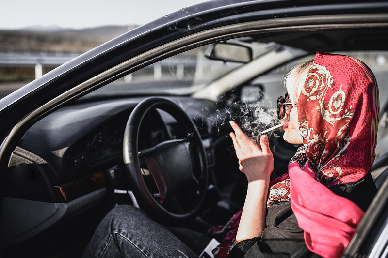 戴围巾的女司机在车里抽烟