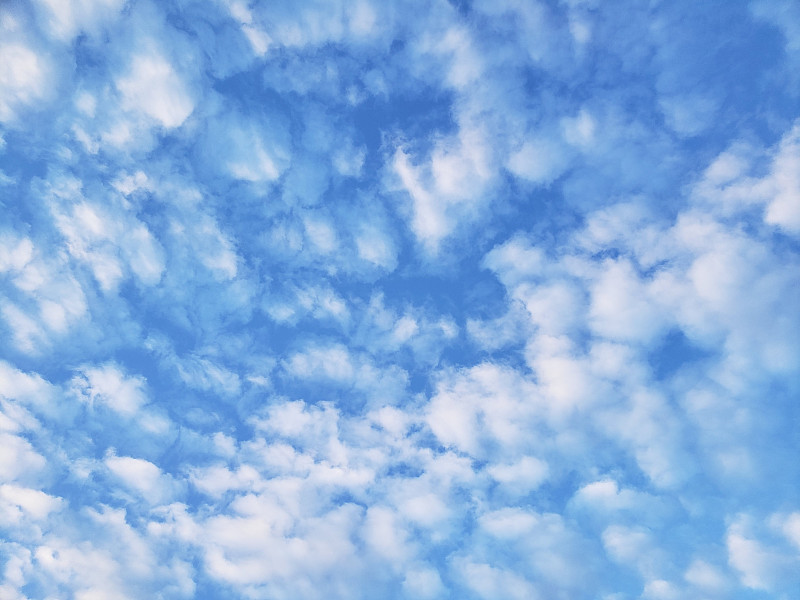 蓝色天空上的小白云的背景纹理图像