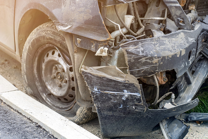 近距离观察黑色汽车事故与坏保险杠。在城市道路上发生车祸。