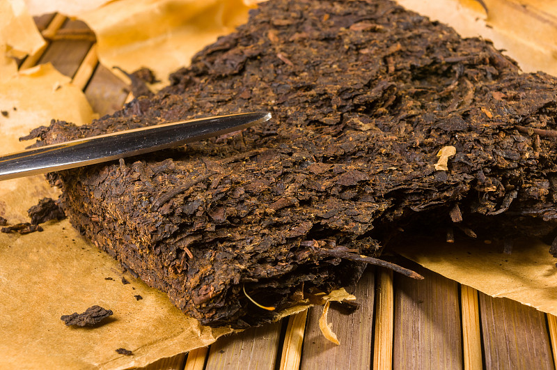 中国压普洱茶的包装纸和茶刀，特写，宏观