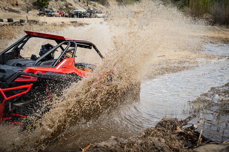 全地形车、越野车在泥泞的小路上艰难地行驶
