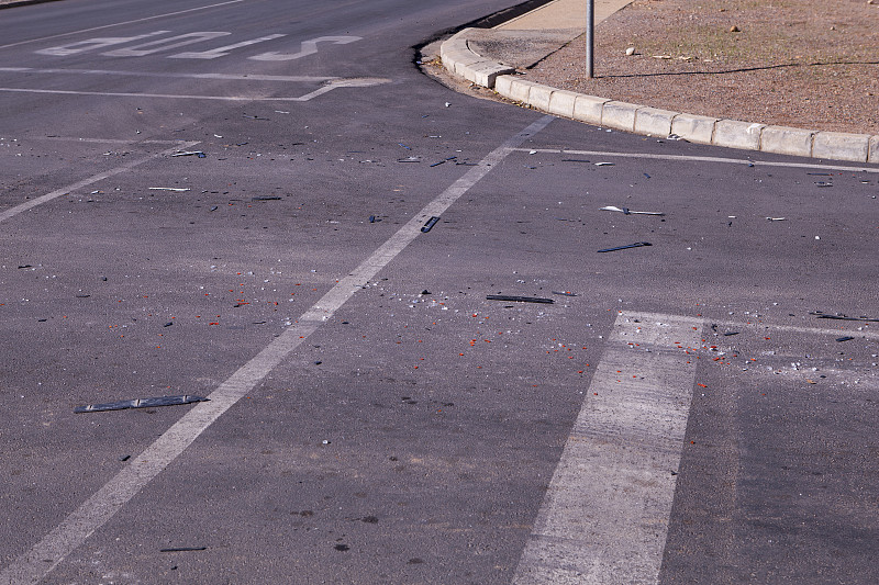 这是一张车祸现场的照片，路面上有碎玻璃和橡胶碎片。