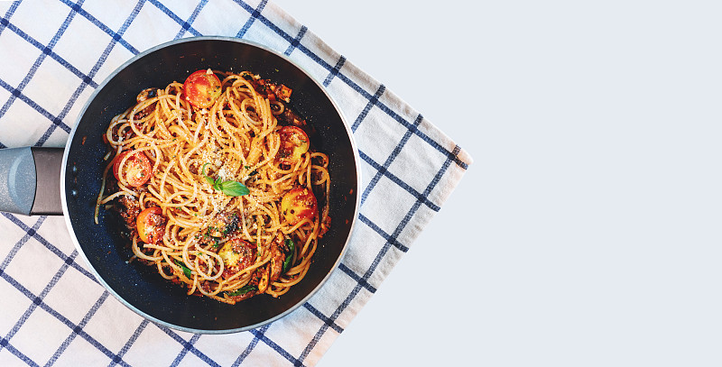 在煎锅中放入蕃茄酱，背景白色。俯视图