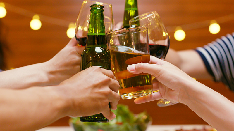 一群快乐的亚洲年轻人和朋友在晚宴上碰杯庆祝