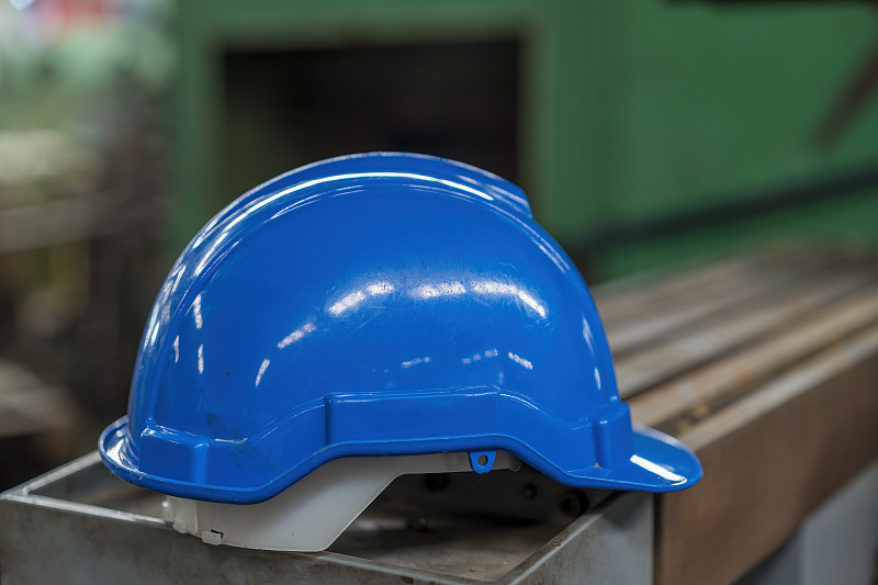 蓝色安全帽。工厂里的蓝色建筑帽。