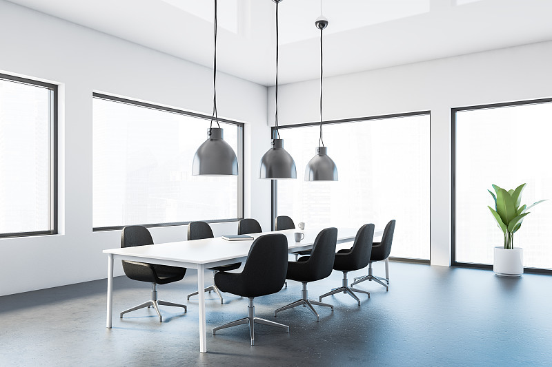 白色的会议室角落，黑色的椅子