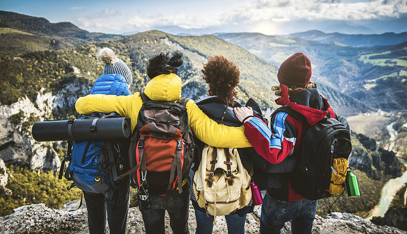 一群人站在山顶-快乐的朋友背着背包一起度过徒步周末-运动，旅行和徒步的概念