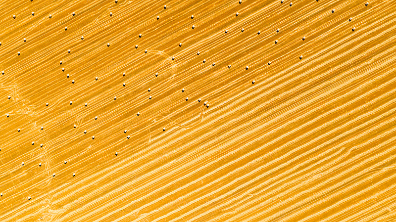 田野鸟瞰图与内衬稻草包在农田上