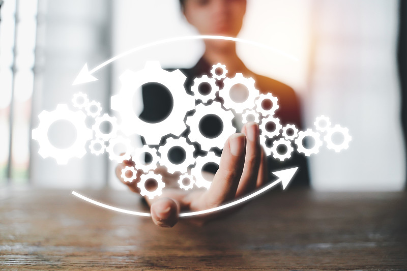 企业机制的概念。商人持有与连接的齿轮图标和业务流程工作流程在虚拟屏幕上。